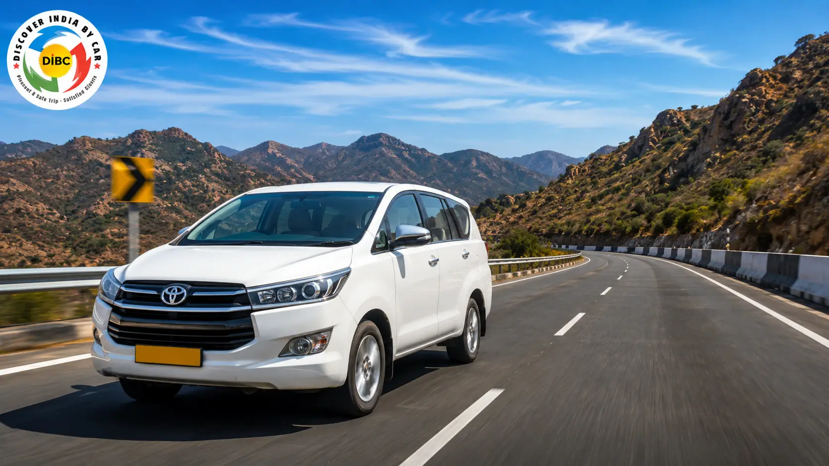 A modern white sedan driving on a clean highway through the scenic Aravalli hills toward Udaipur
